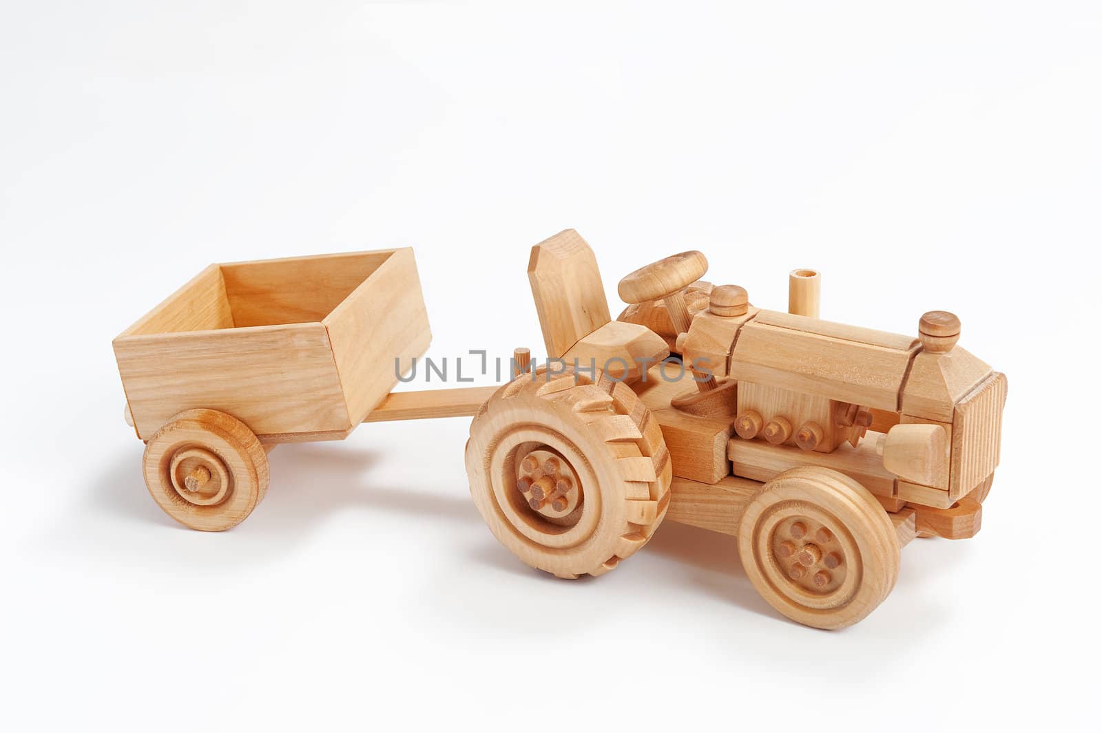 Wooden toy tractor with trailer on white isolated background