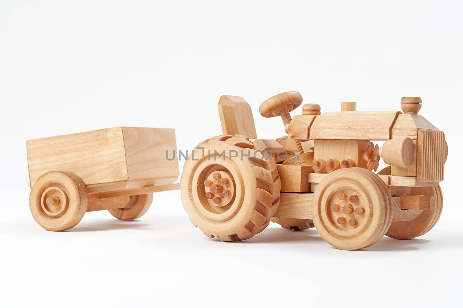 Wooden toy tractor with trailer on white isolated background