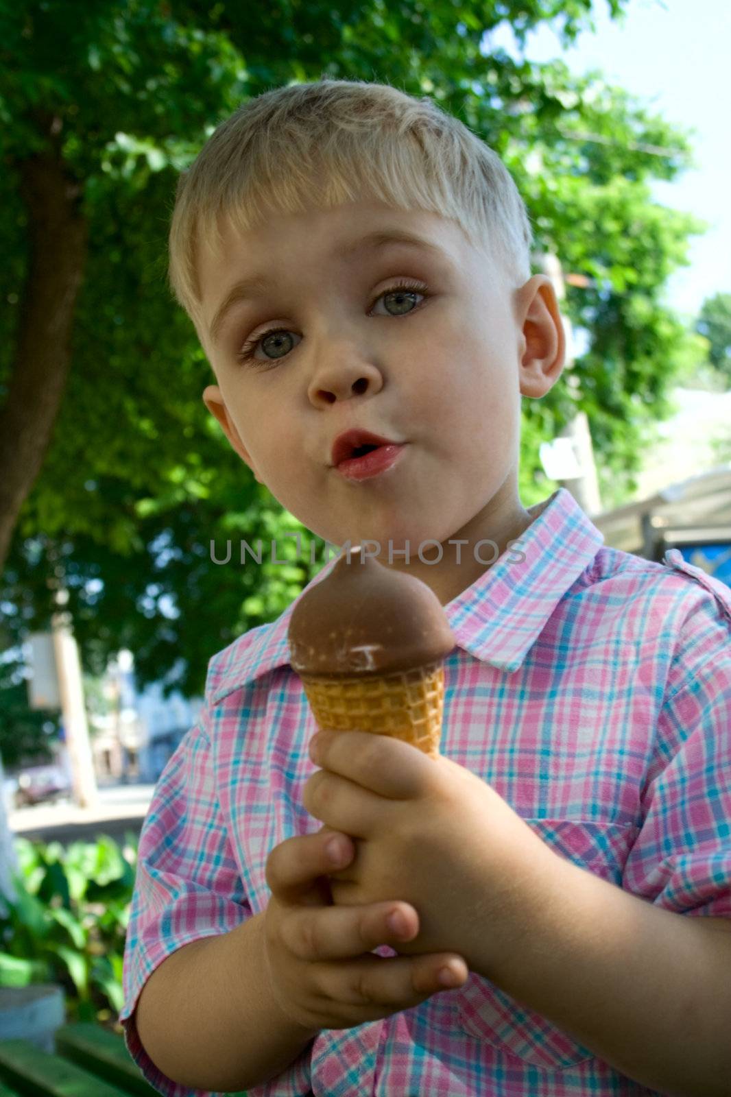 The little boy holds ice-cream. Emotion of surprise