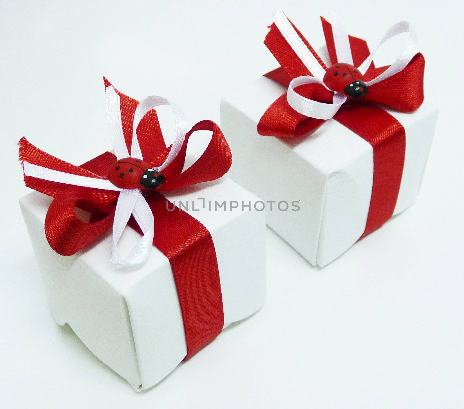 White gift boxes with red ribbons and ladybugs