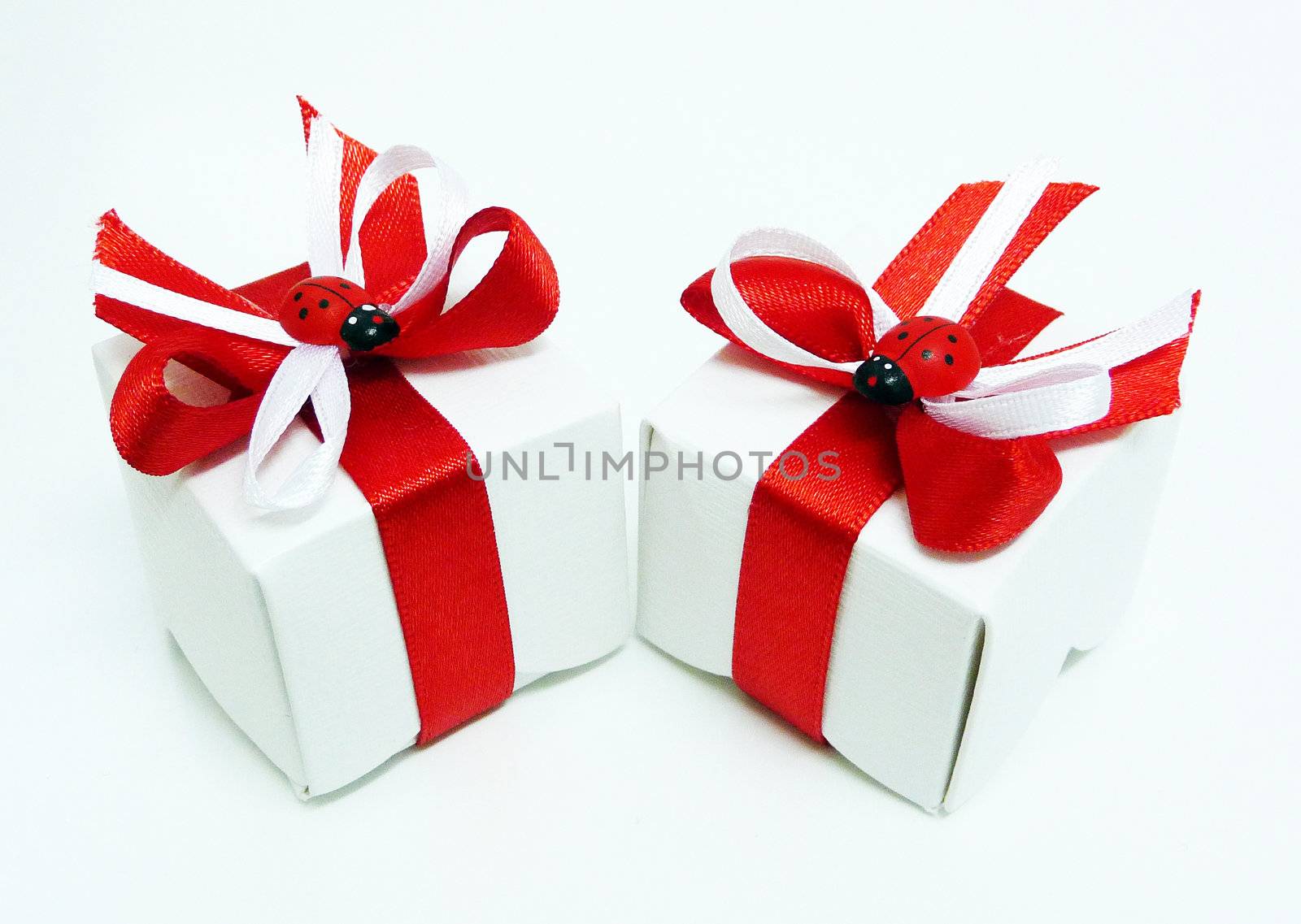 White gift boxes with red ribbons and ladybugs