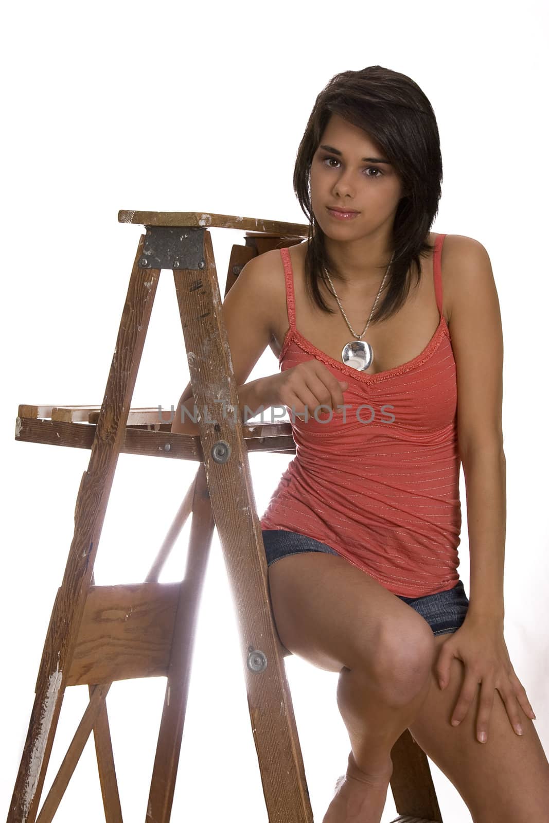 teen girl sitting on a wood ladder