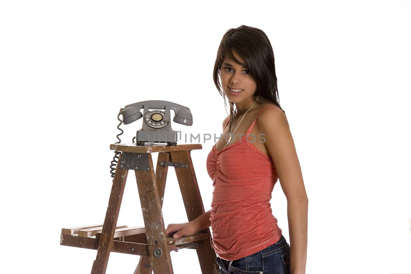 teenage girl standing on wood ladder with old rotary phone