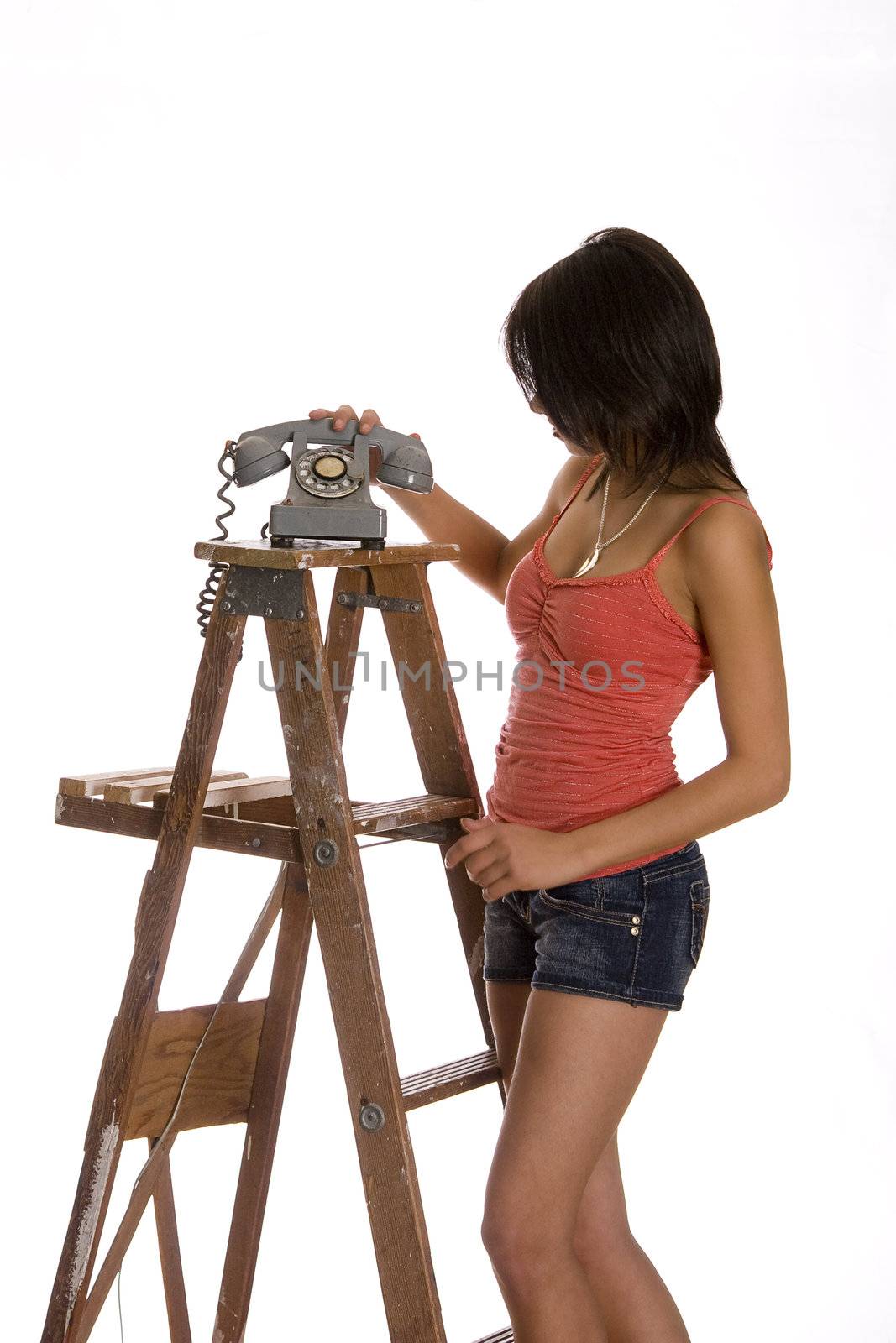 teenage girl standing on ladder about the anwser phone