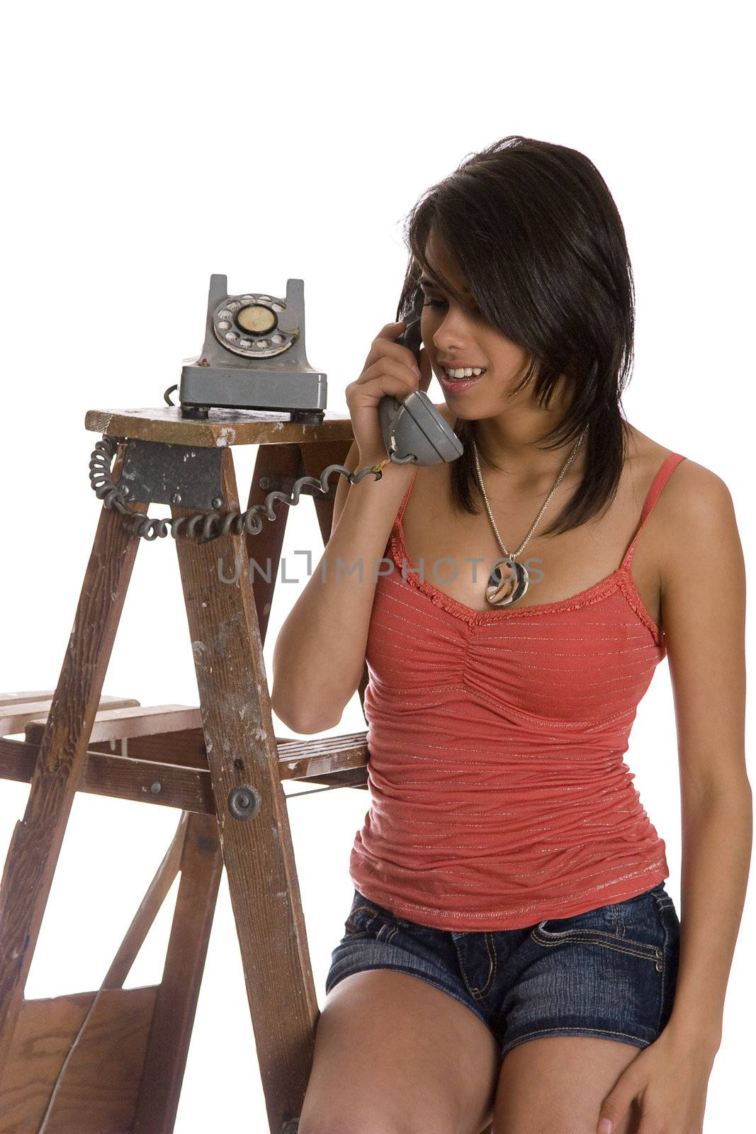 teenage girl standing on ladder talking on a old rotary phone