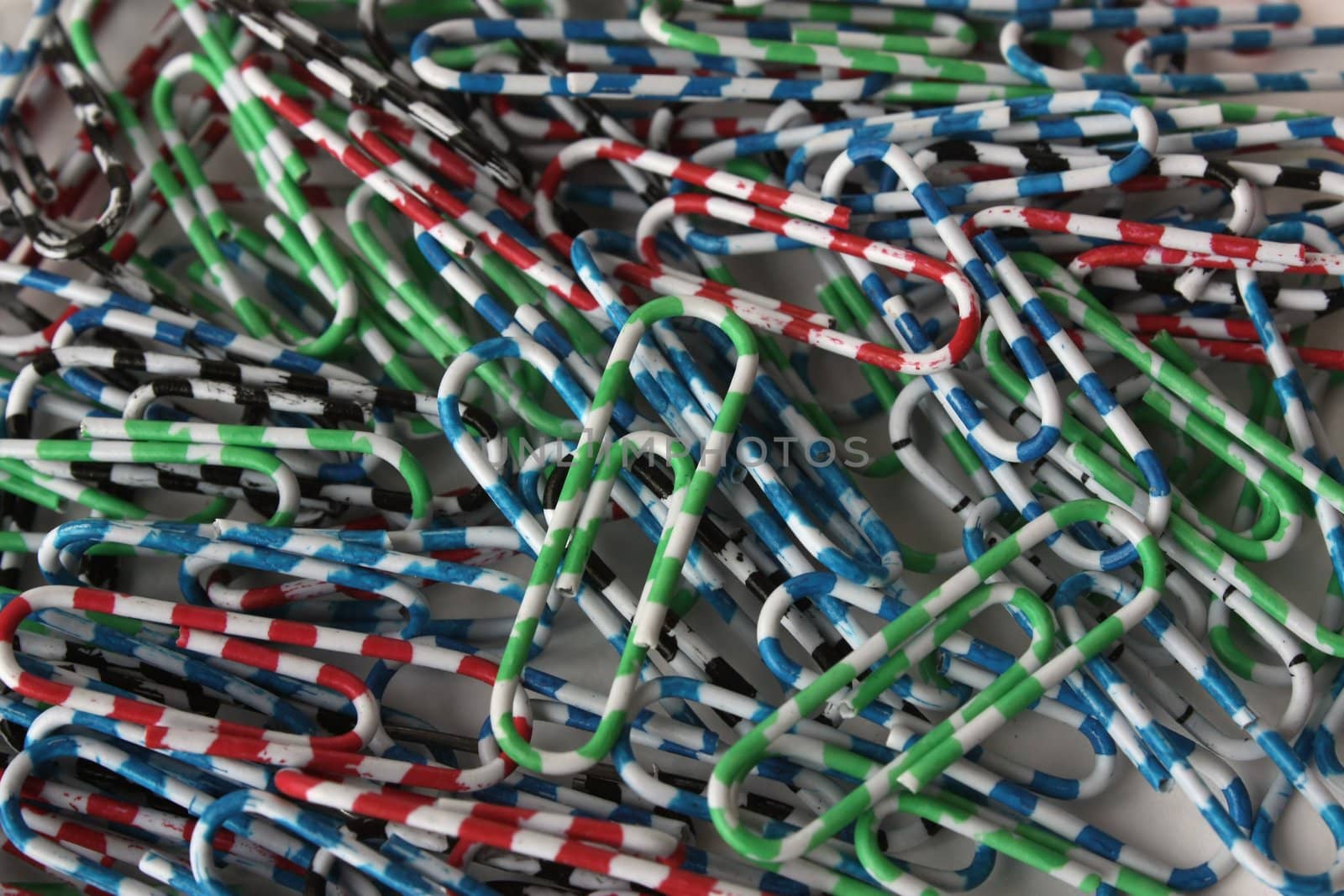 On a table paper clips are scattered. They of different colours. They bright.