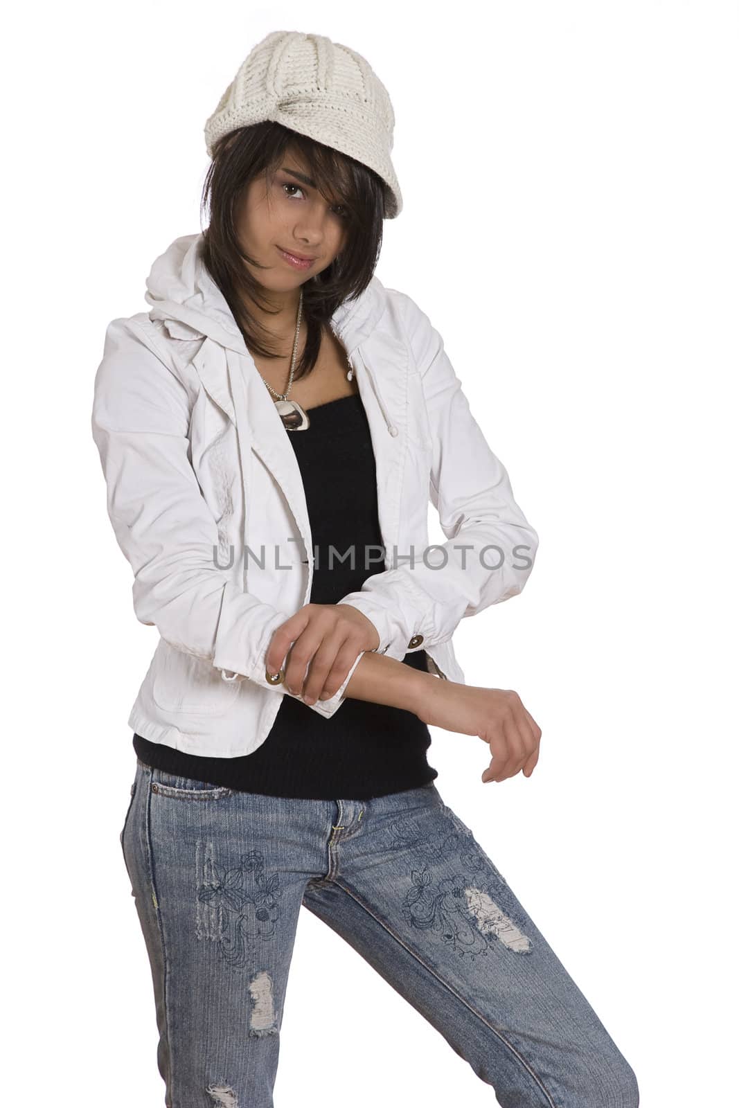 Teenage girl pulling up her sleeve wearing knitted hat and jeans with holes