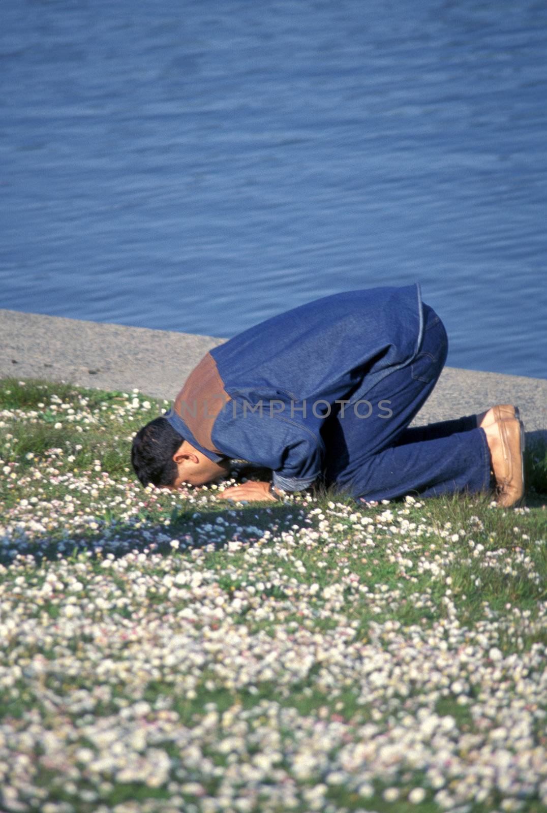 Muslim man praying on the ground.