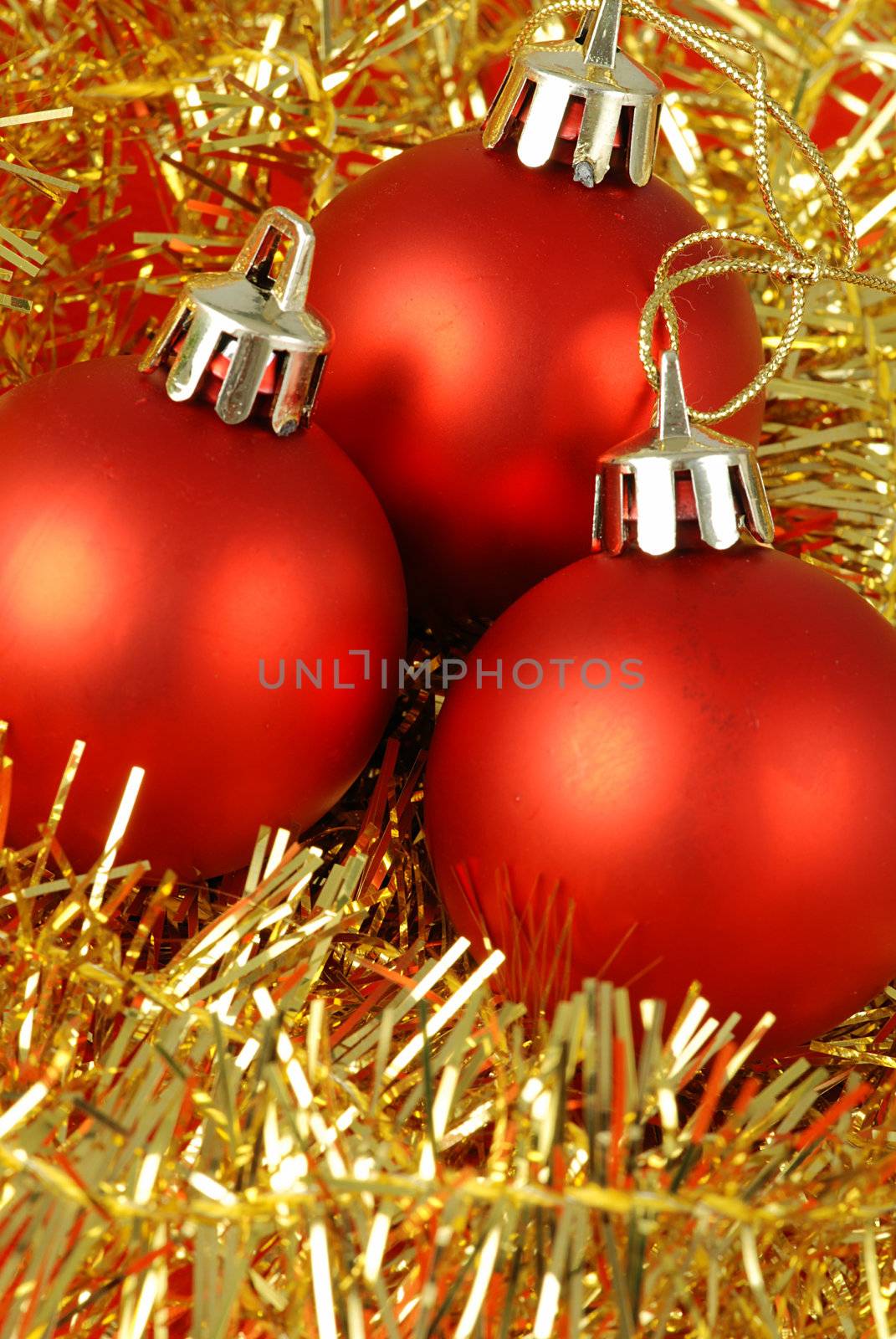 Detail of three christmas balls and chain on a red background