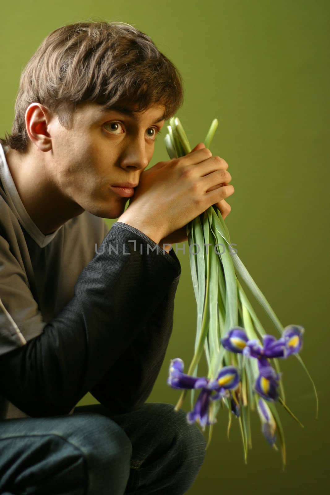 Young the man with a bouquet of irises in hands