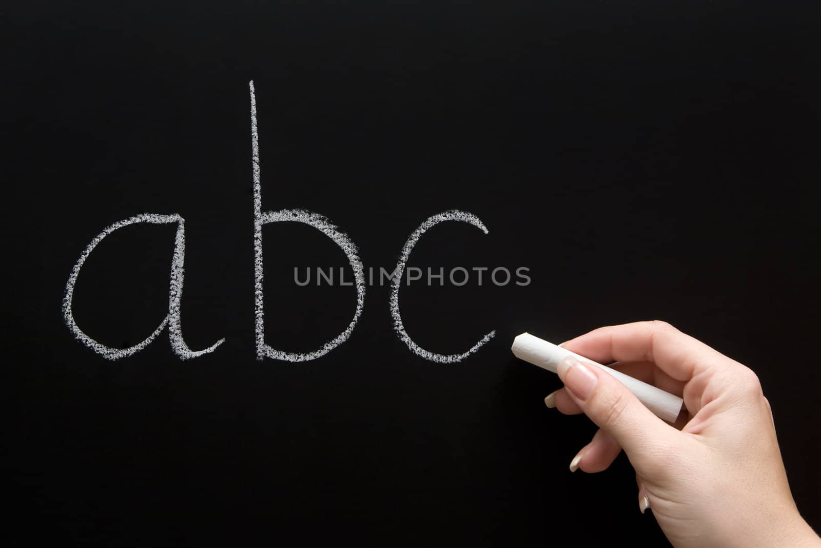 Female teacher writing on a chalkboard.