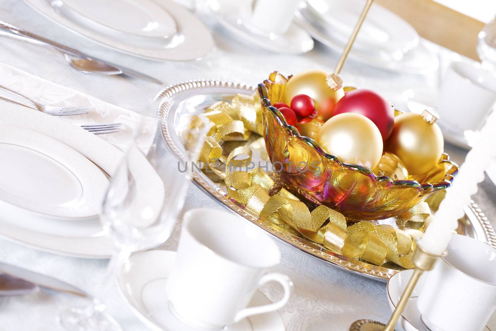 Bowl of red and gold ornaments on table