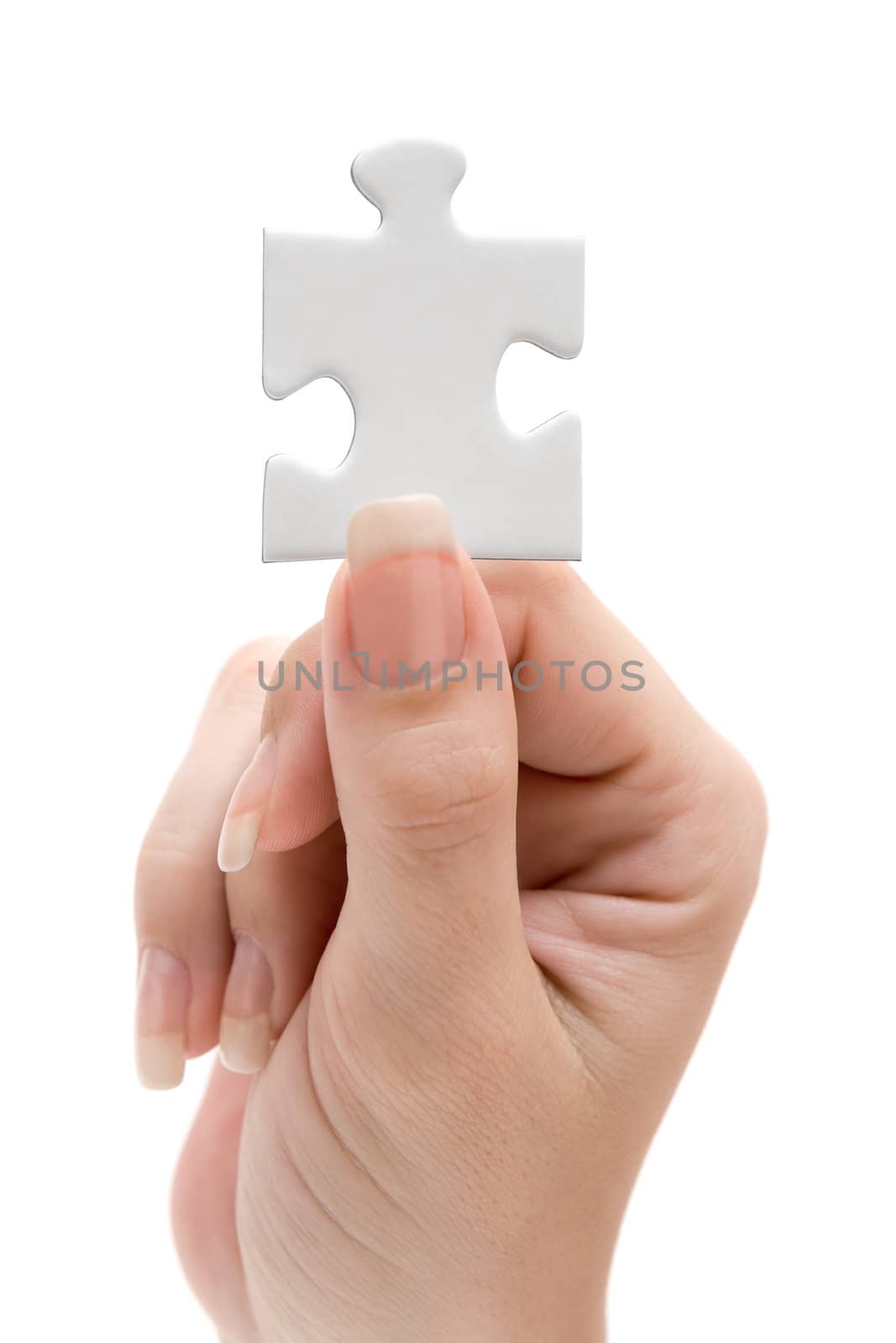 Female hand presenting a single puzzle piece. Isolated on a white background.