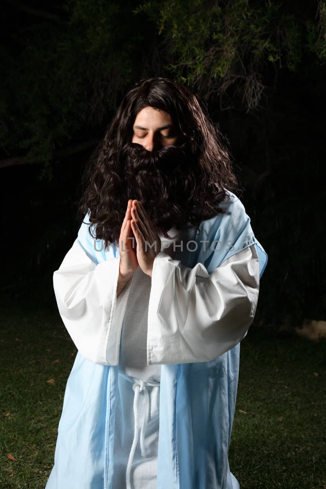 Prophet from old times kneeling in silent prayer or meditation.