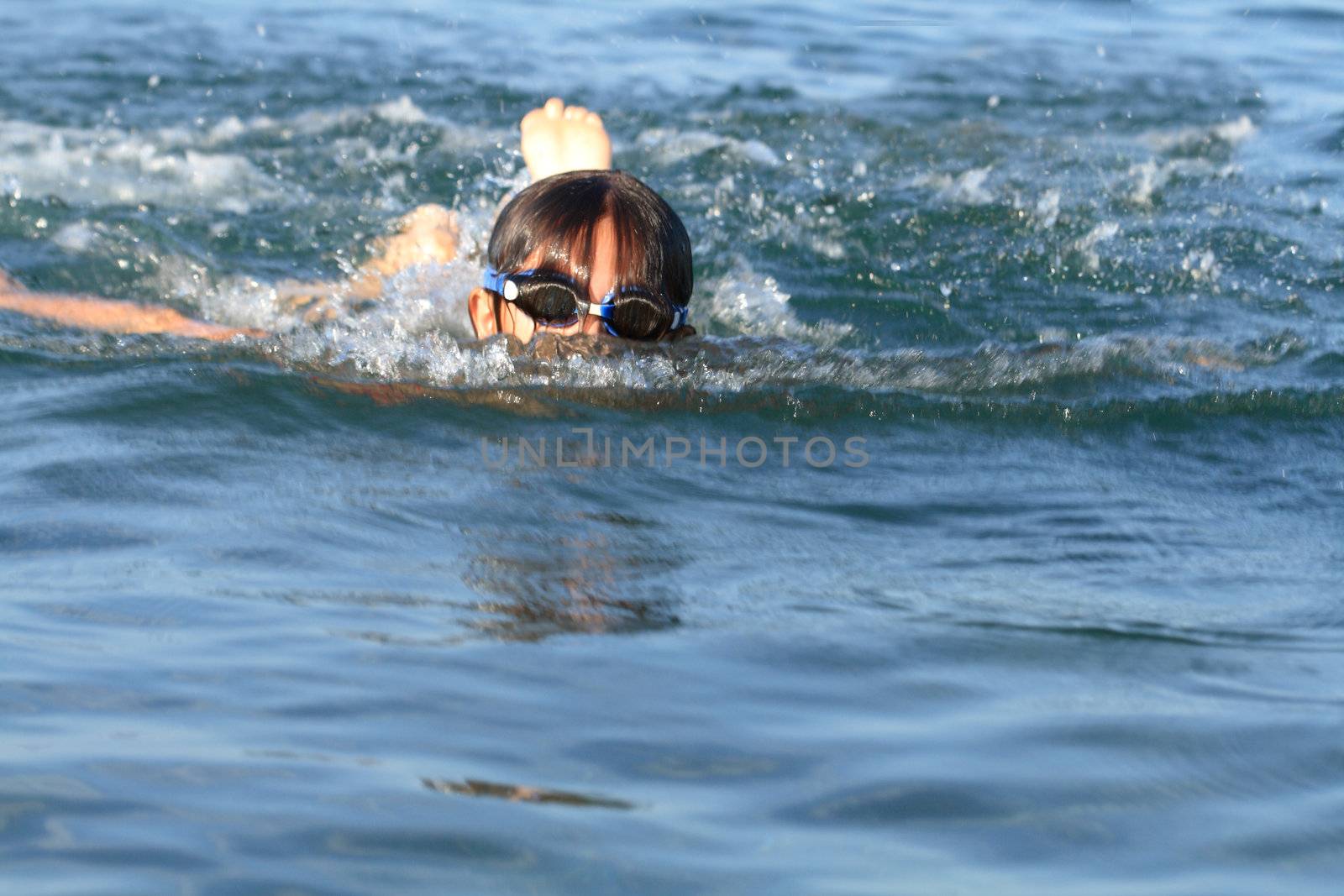 Young girl douing the butterfly swimming in the sea