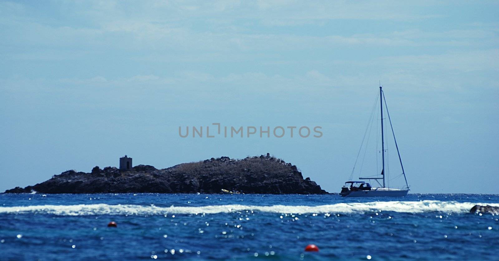 Small yacht is docking near the island with a shrine