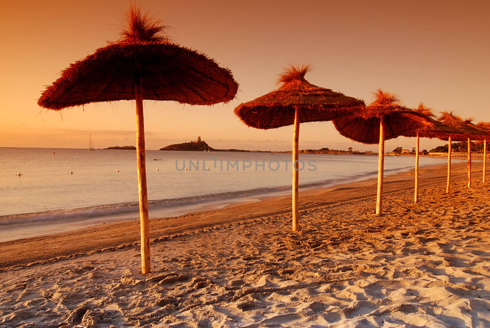 Ubrellas on the empty beach early evening by the sunset