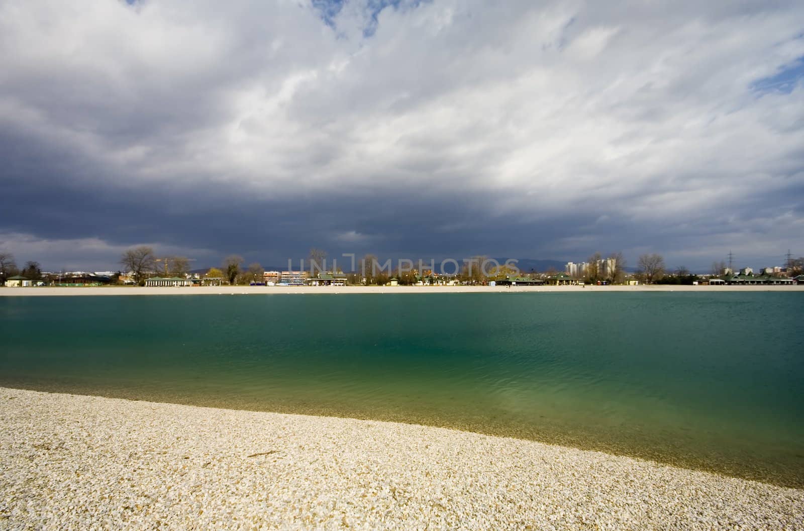 Lake with shore and stormy clouds