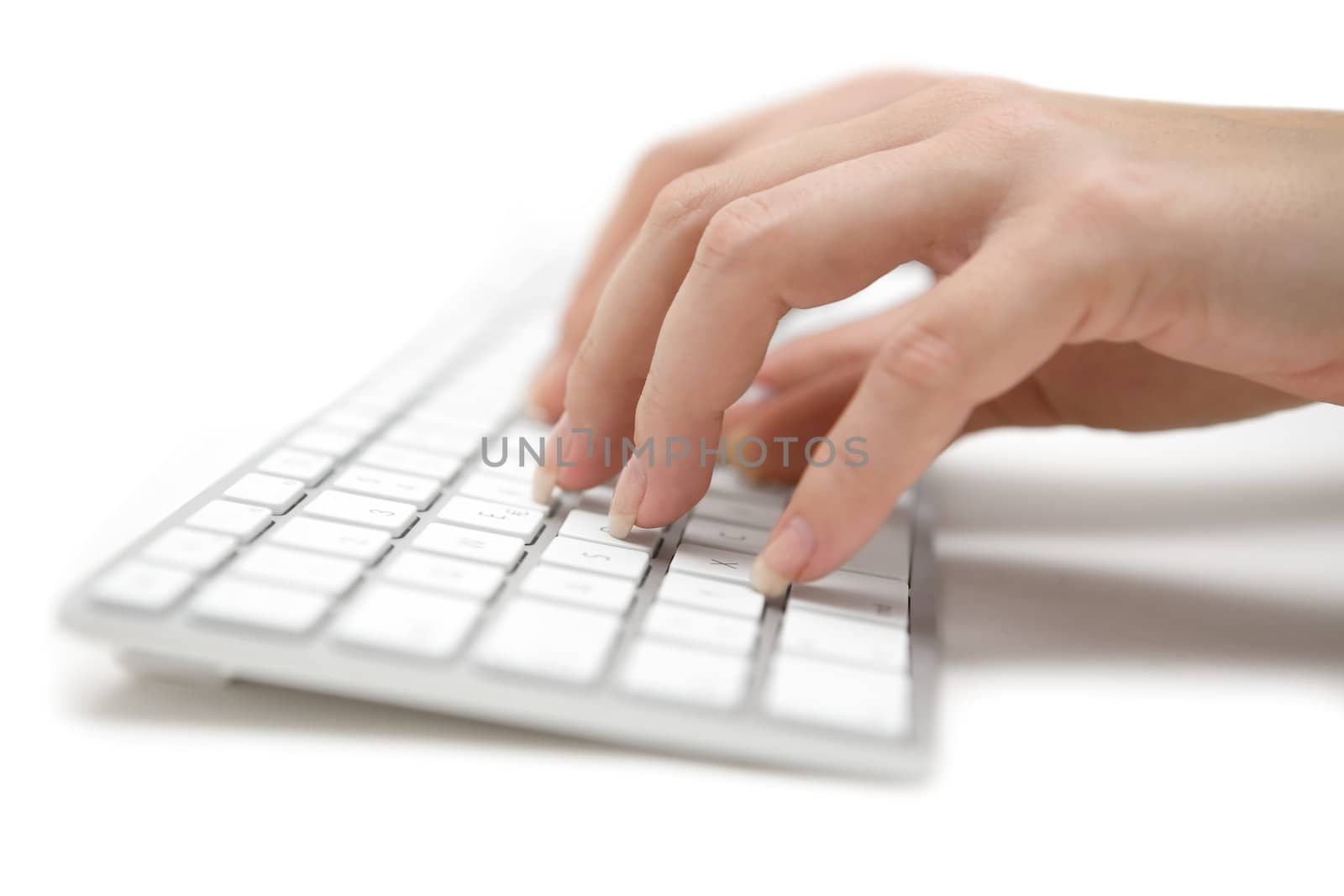 Woman typing on a white computer keyboard. Shallow depth of field. White background.