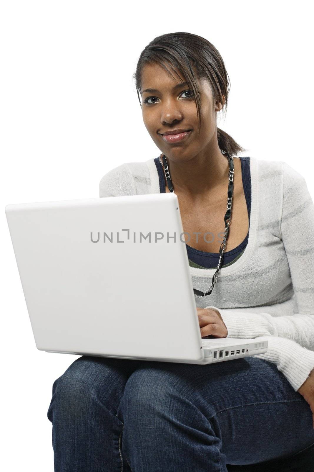 A beautiful female student sitting browsing with her laptop.
