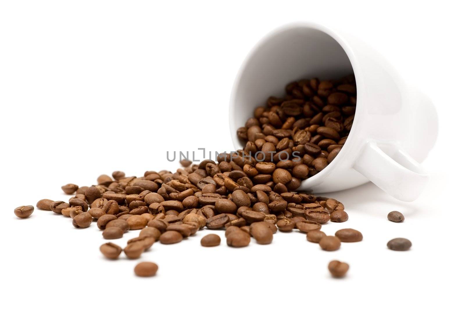 White cup and coffee beans. Shallow depth of field. White background.