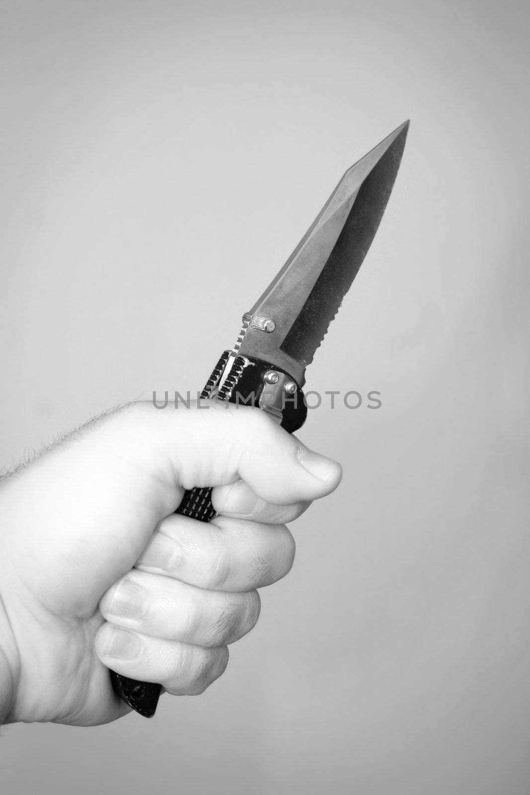 A hand gripping a scary looking knife.