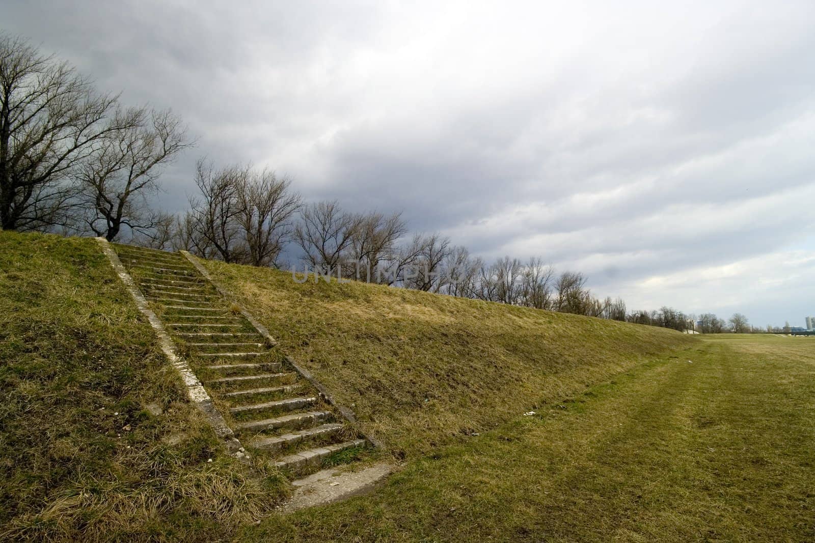 Stairs on a slope with stormy clouds