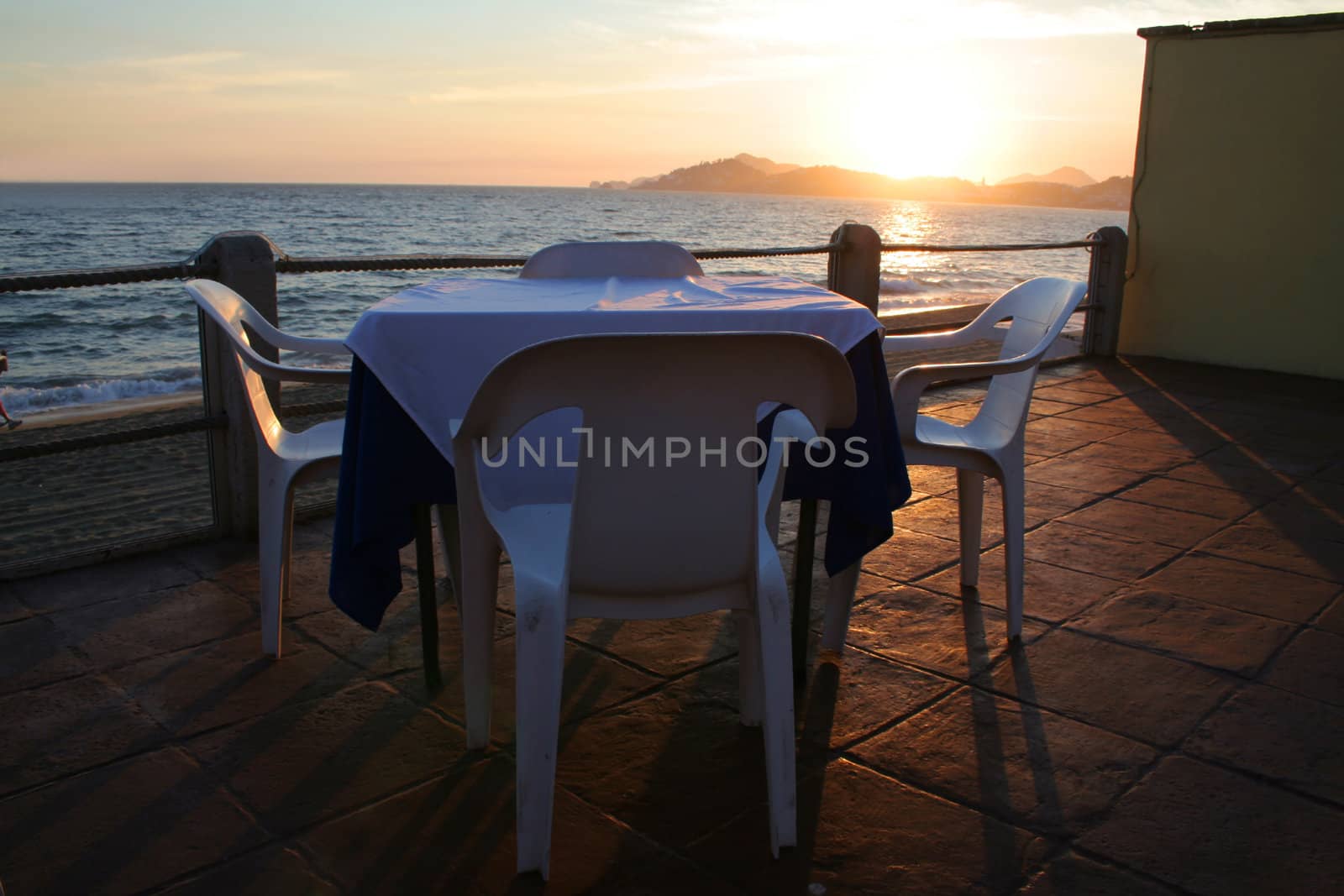 Restaurant table overlooking ocean at sunset