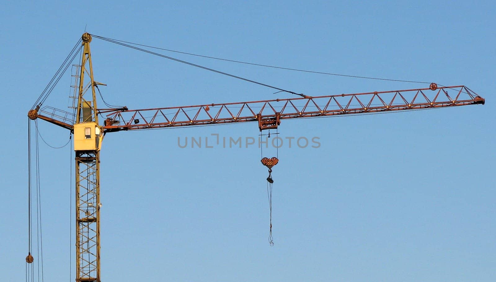 the hoisting crane on the blue sky background
