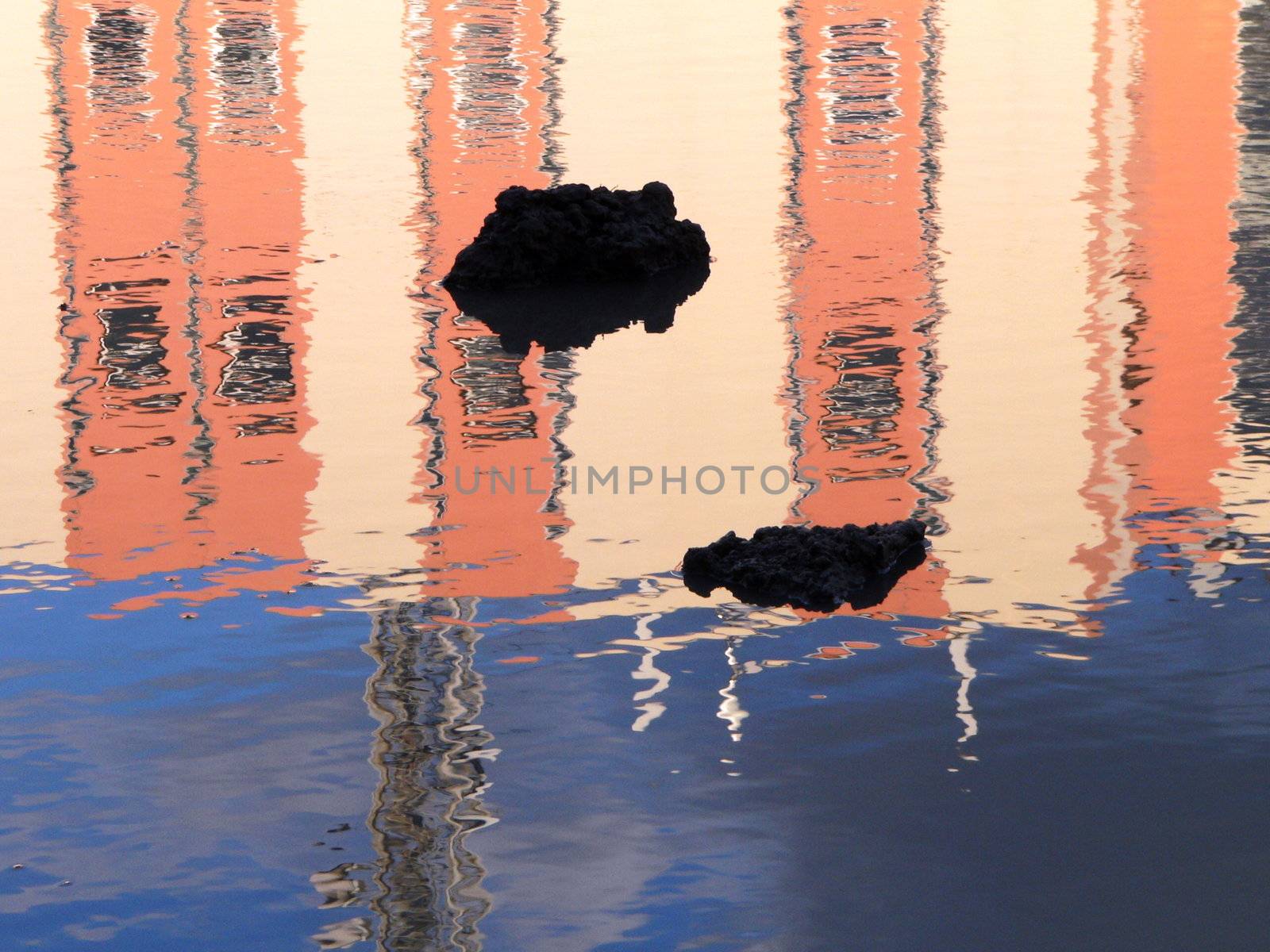 Reflection of pink wall in the puddle