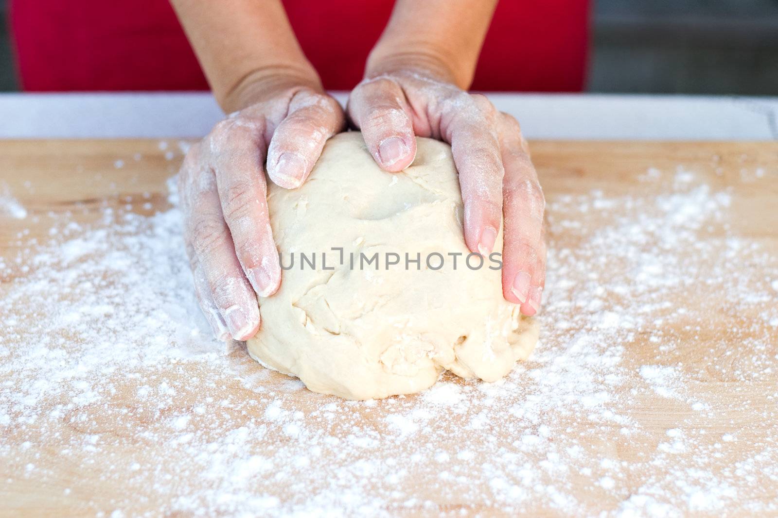 Woman hands kneading dough 