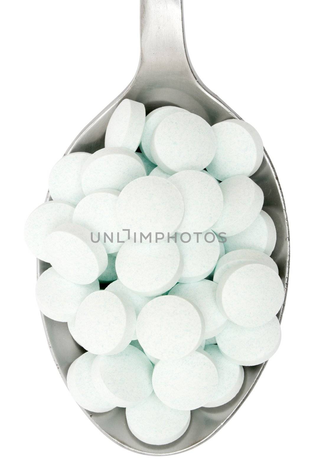 Silver spoon full of tablets. Isolated on a white background.