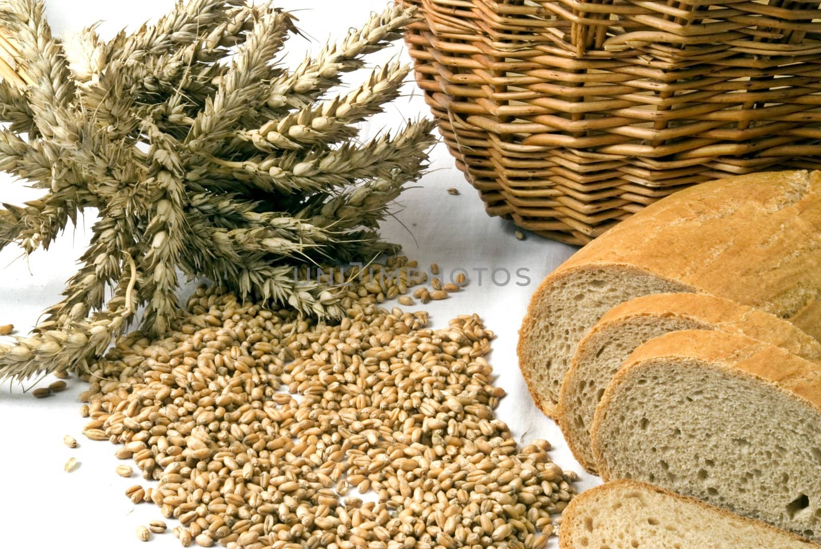 Bread with grain and basket isolated on white