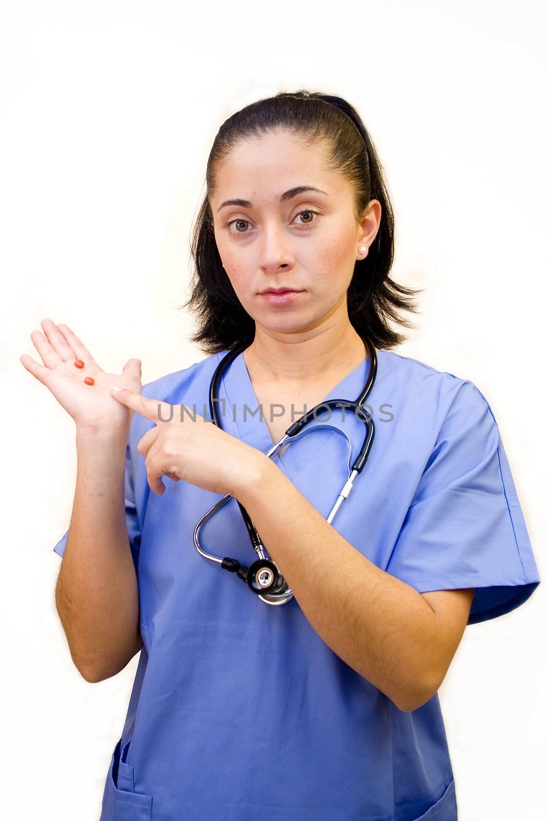 Pretty Hispanic nurse isolated on white holding pills in her palm