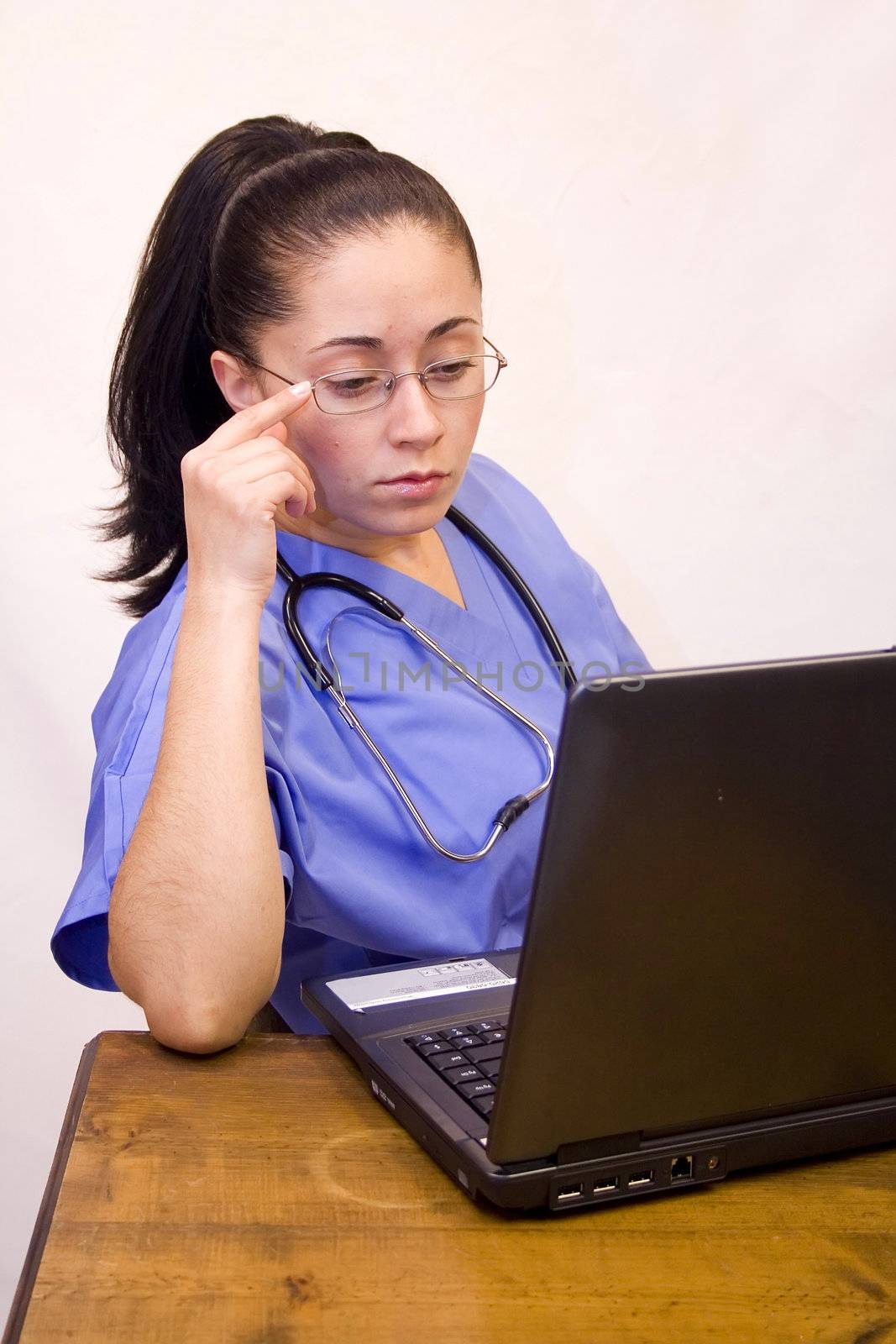 Pretty Hispanic nurse isolated on white with laptop