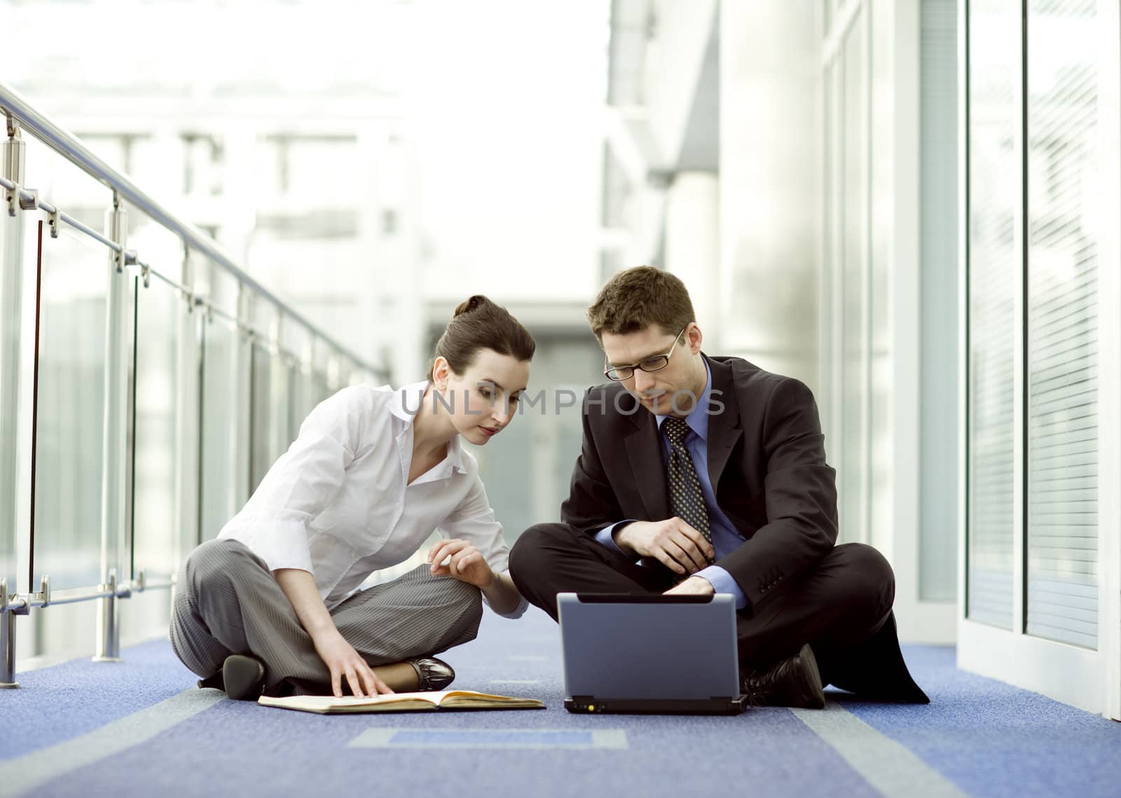 Business couple portrait - young man and woman working together on the floor