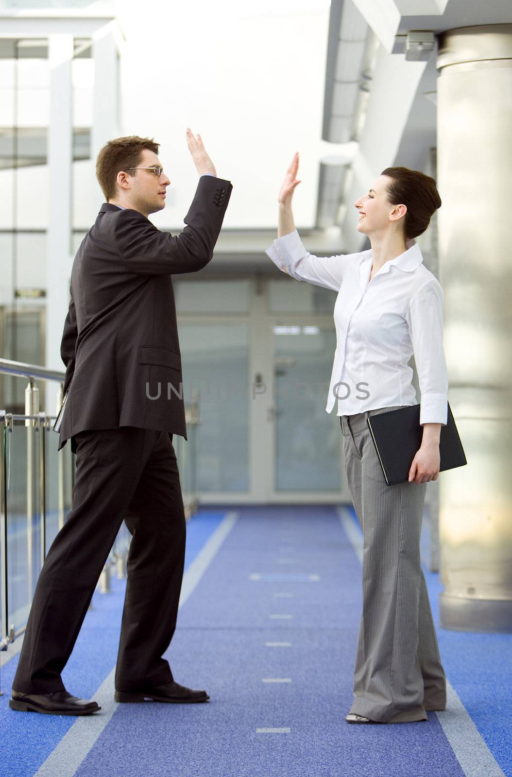 Businessman and businesswoman celebrating success by doing the high-five