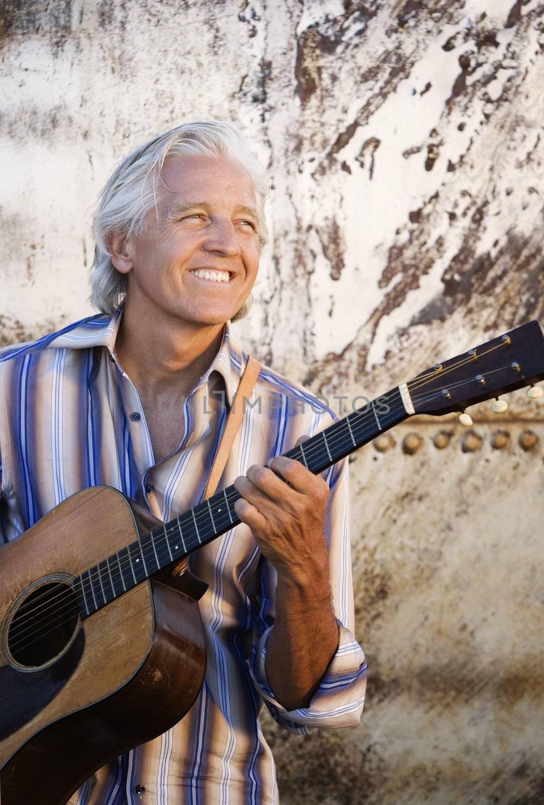 Guitar player with his instrument in golden light