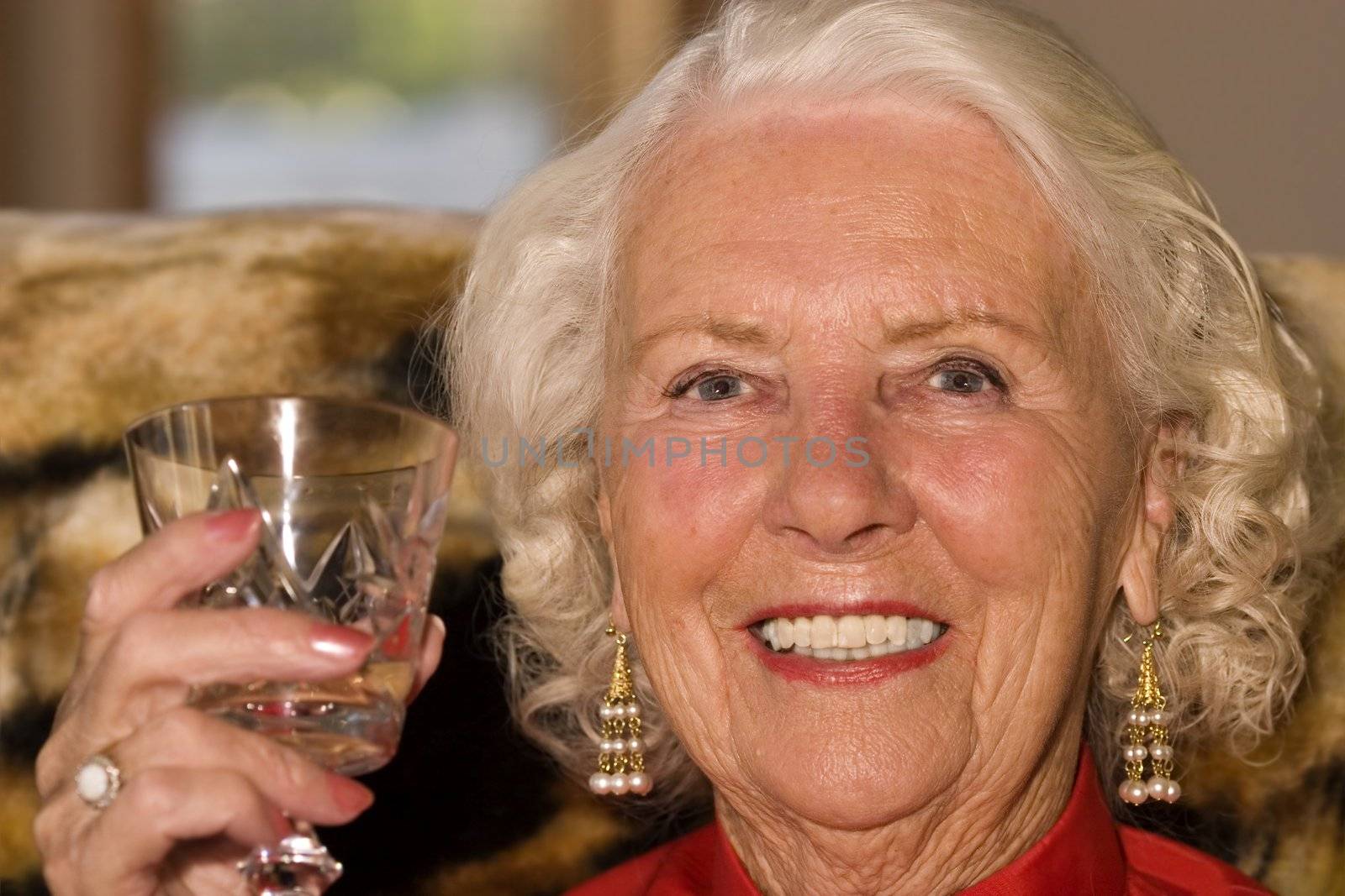 Beautiful elderly woman in her eighties enjoying a drink