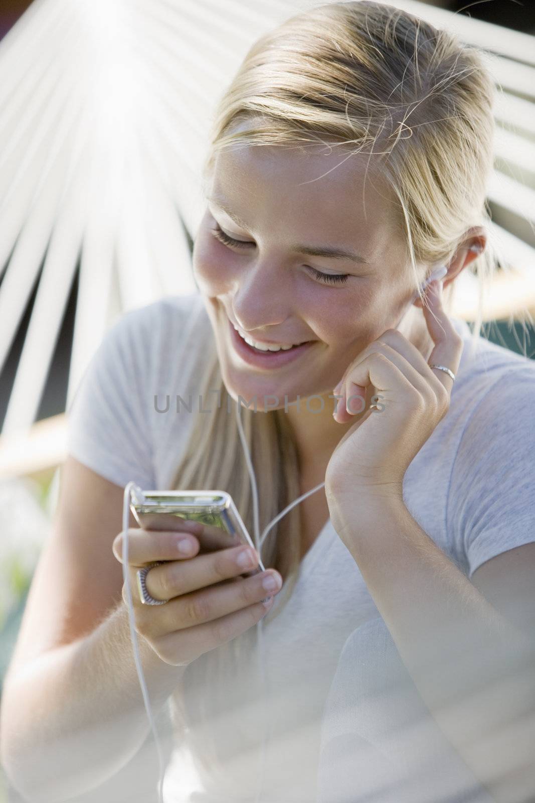 Teenager with earbuds listening to MP3 player