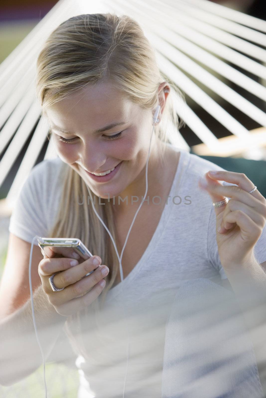Girl listening to MP3 player and snapping fingers by edbockstock