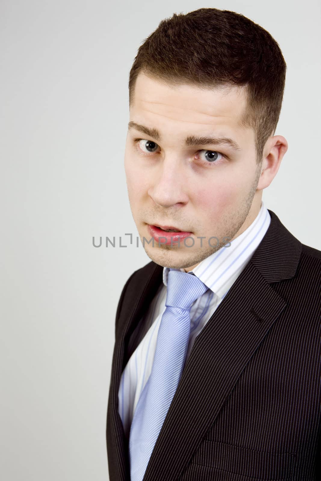 Portrait of young man in business clothes looking agressively at camera