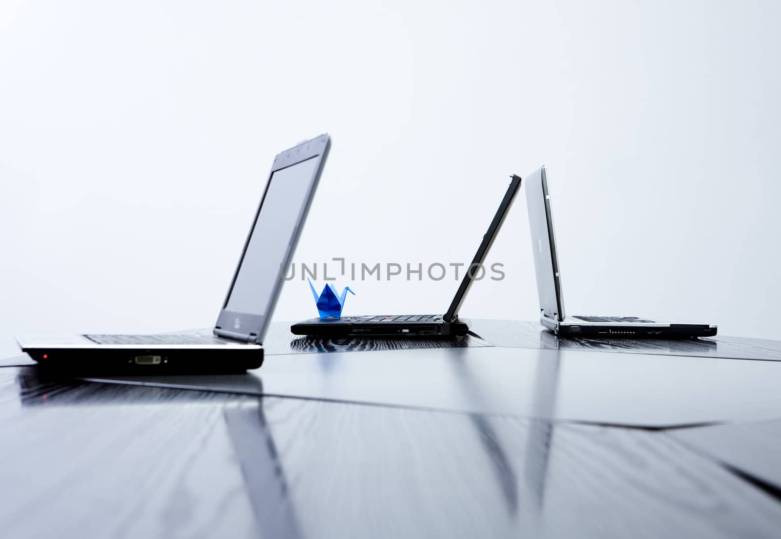 Composition of three notebooks with blue origami animal on one of them