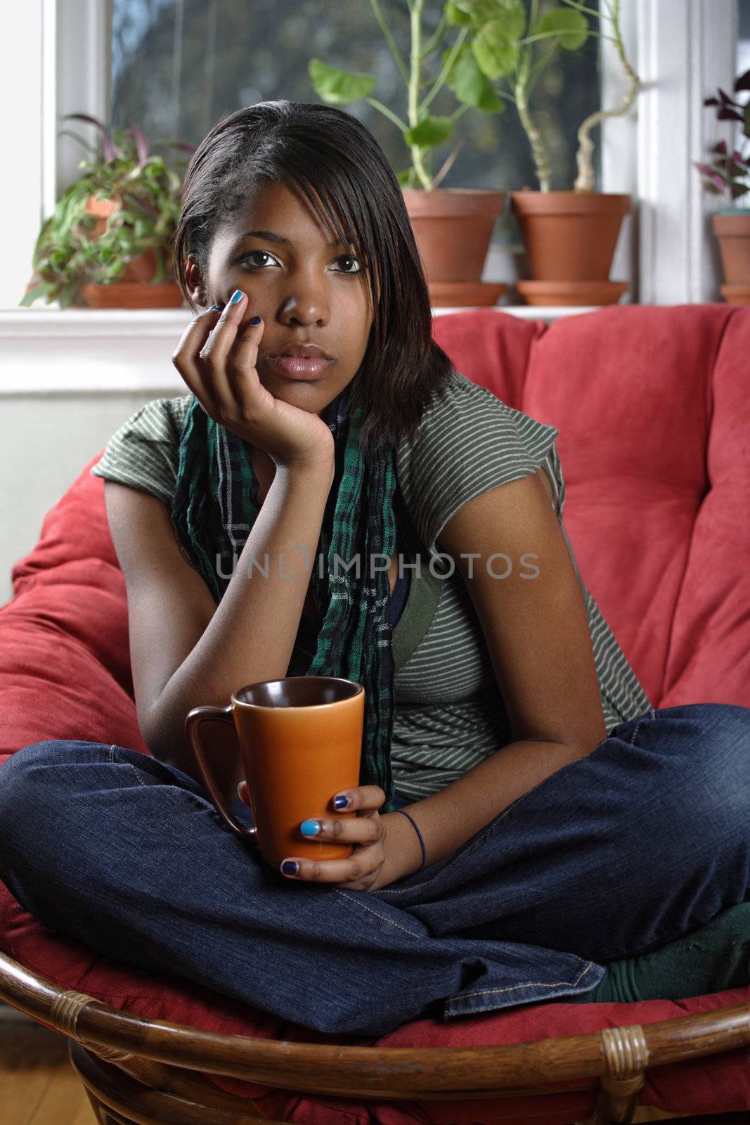A beautiful female relaxing in her home drinking tea or coffee.
