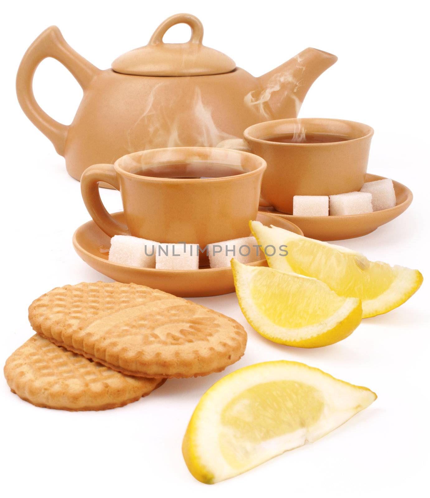 set of the earthenware teapot, two cups of tea, lump shugar, sliced lemon and biscuits isolated on white background with clipping path                     
