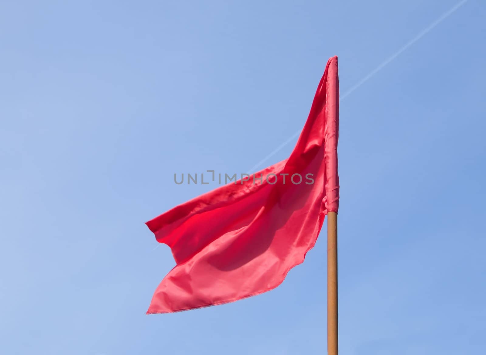The red flag  flutters a wind. Sunny day
