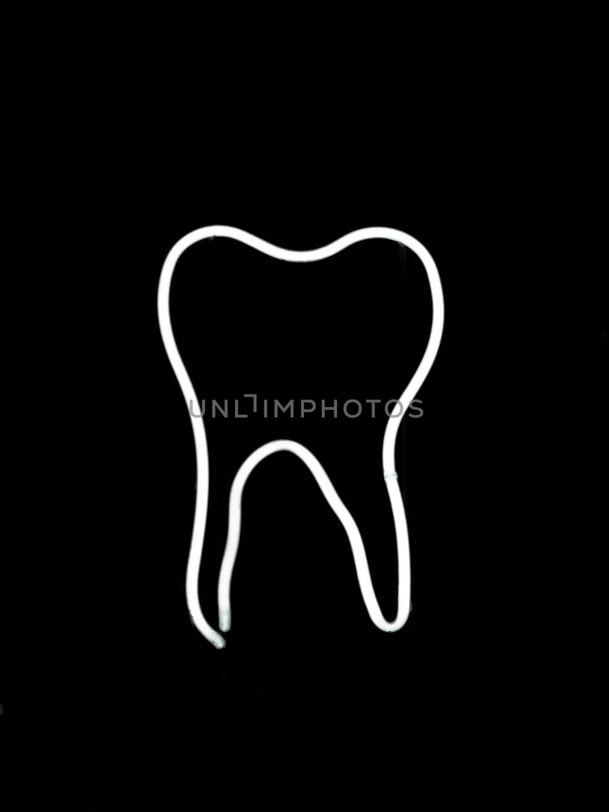 Neon sign shaped like a tooth on black