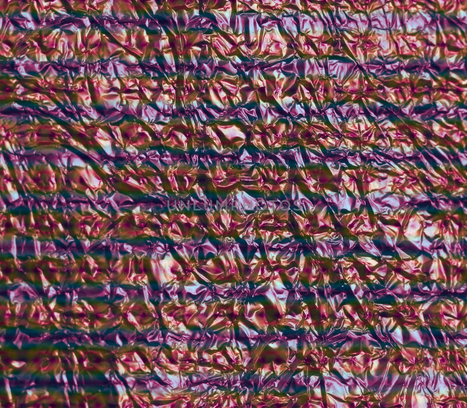 A crinkled sheet of aluminum foil with colorful stripes