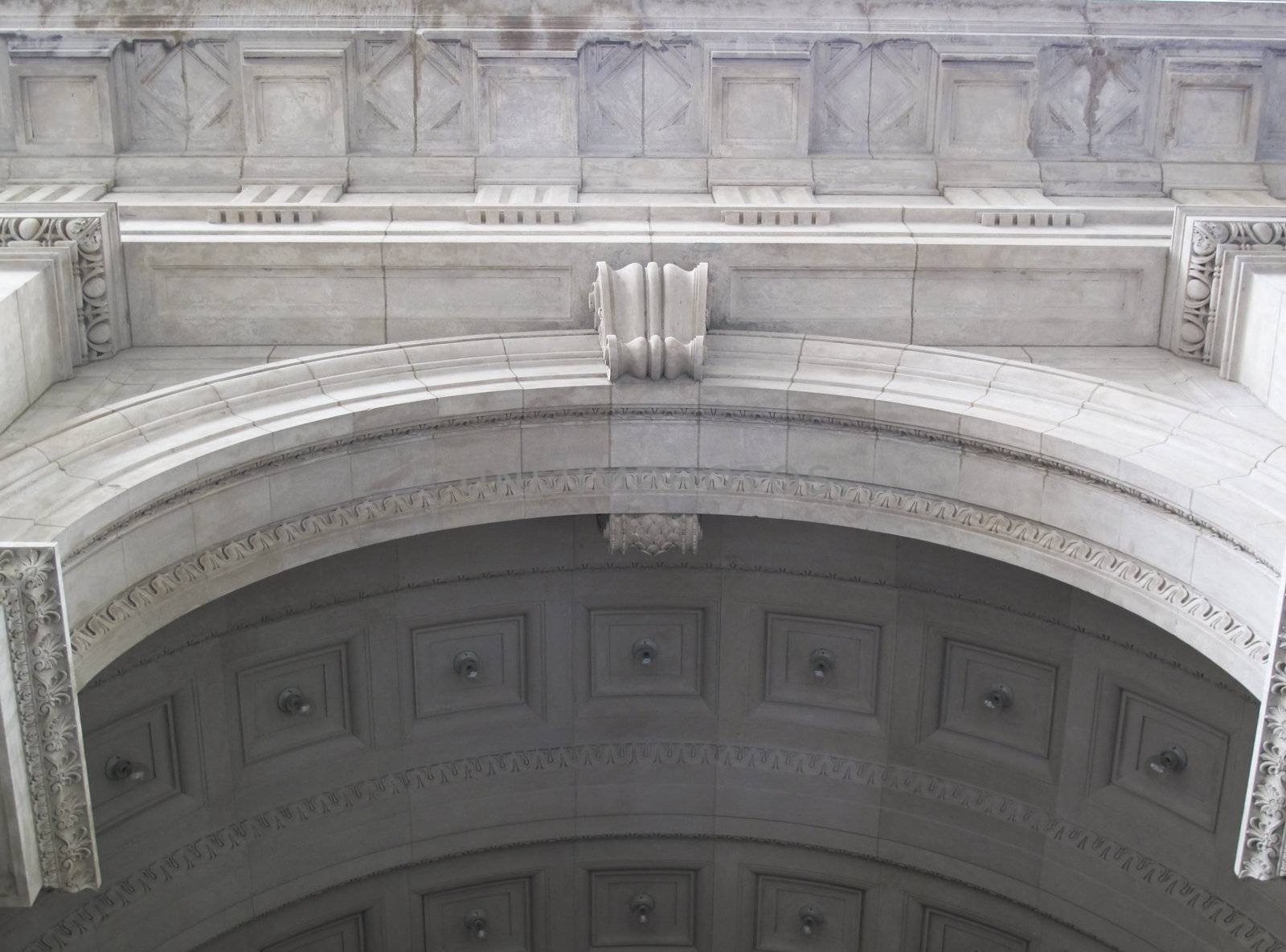 Underneath an old stone archway of a building