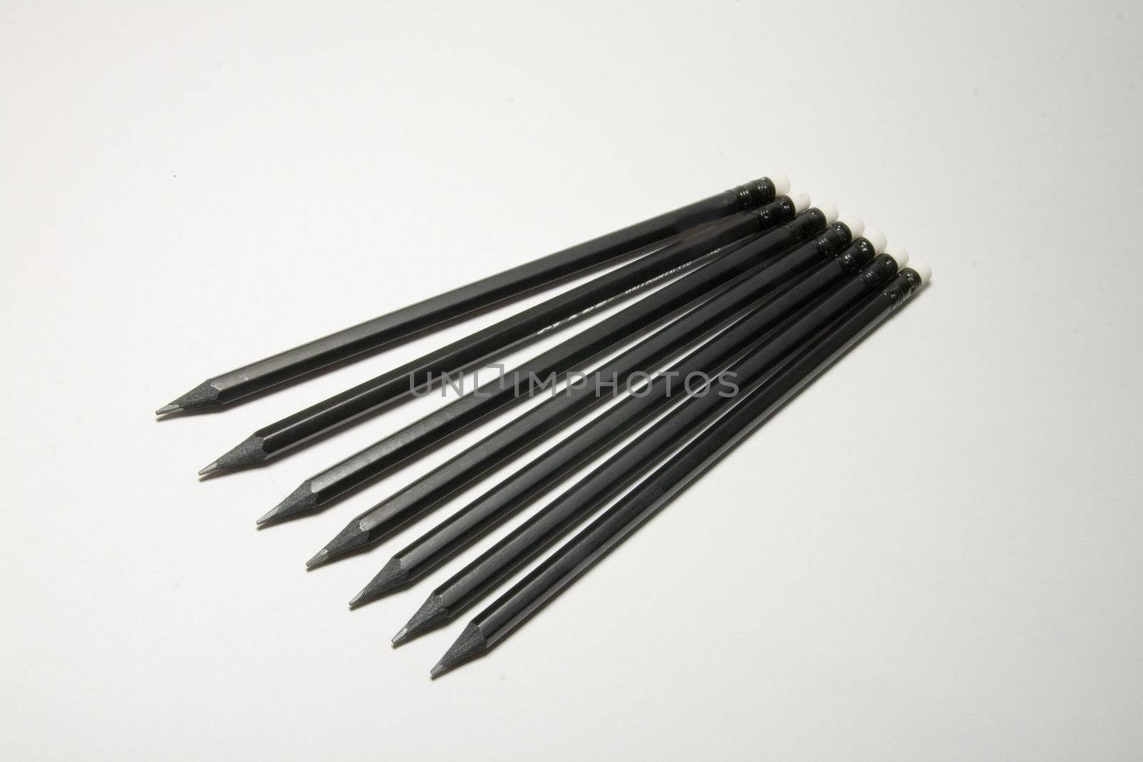 Many black pencils on a white background